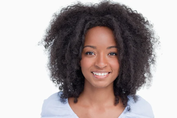 Ung kvinna med krullig frisyr visar ett stort leende — Stockfoto