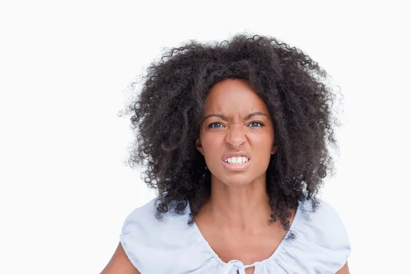 Young woman with curly hairstyle showing teeth to indicate her a — Stock Photo, Image