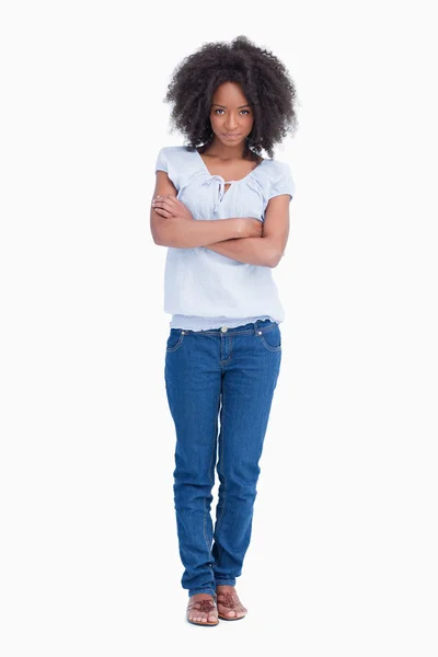 Young serious woman crossing her arms while standing upright — Stock Photo, Image