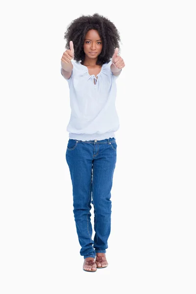 Mladá seriózní žena uvedení její dva palce nahoru před ní — Stock fotografie