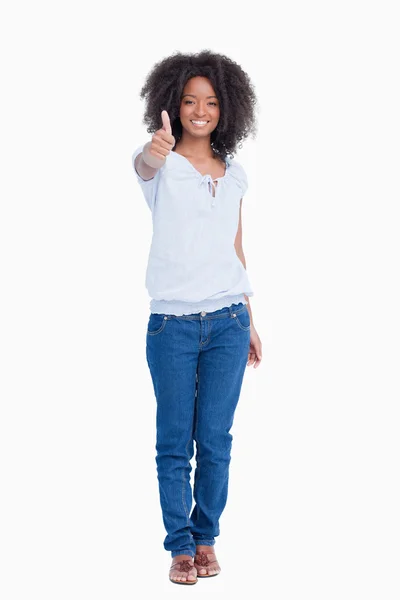Ung kvinna visar ett stort leende medan placera hennes tummar upp — Stockfoto