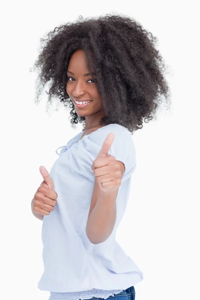 Vista lateral de uma mulher sorridente mostrando seus polegares para cima — Fotografia de Stock