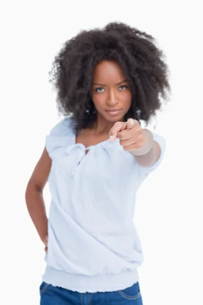 Jeune femme sérieuse avec coiffure bouclée pointant son doigt — Photo