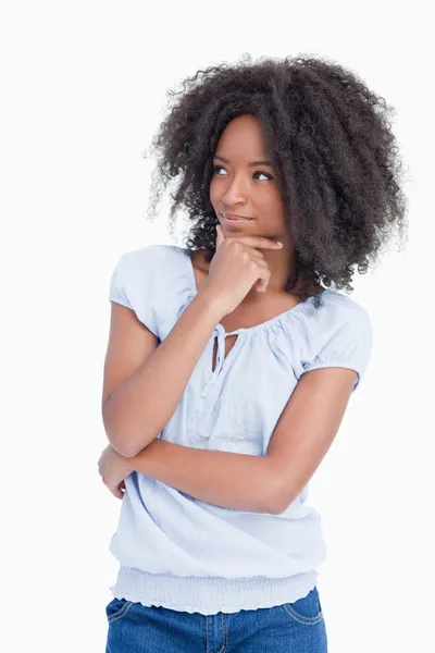 Young woman looking on the side with arms crossed and hand on he — Stock Photo, Image