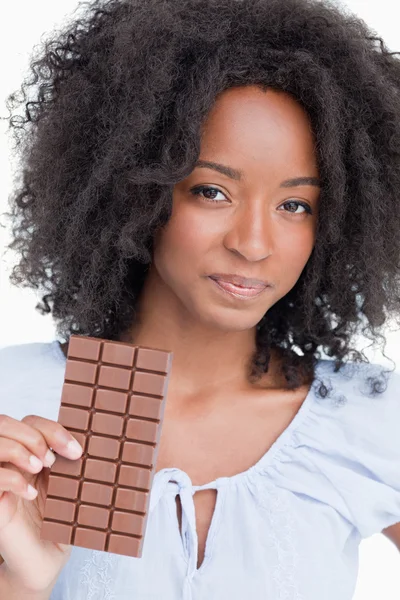 Jovem segurando uma deliciosa barra de chocolate — Fotografia de Stock