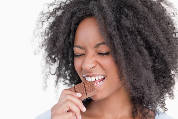 Young woman closing her eyes while eating chocolate — Stock Photo, Image