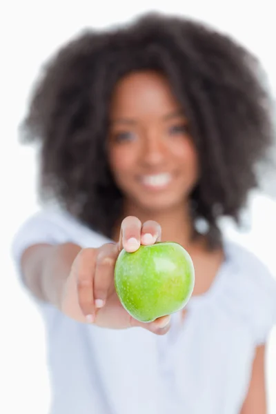 Zelené jablko, držené mladá žena s kudrnatými vlasy — Stock fotografie