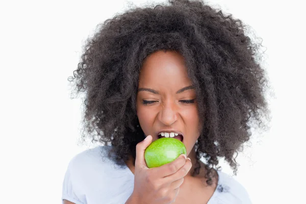 Mujer joven cerrando los ojos mientras come una manzana verde — Foto de Stock