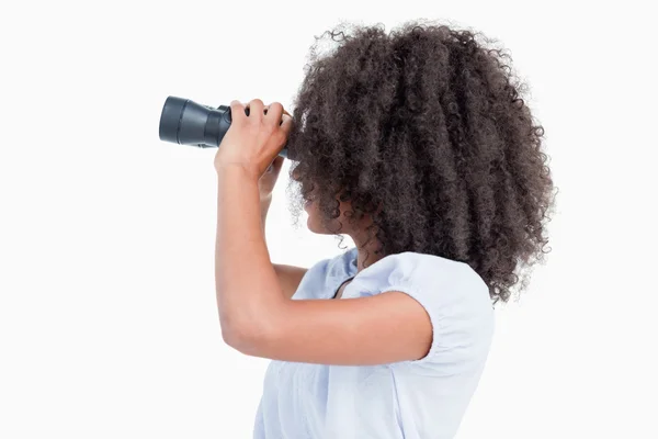Sidovy av en ung kvinna som tittar genom kikare — Stockfoto
