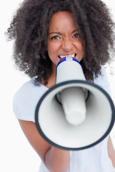Young woman speaking loud into a megaphone — Stock Photo, Image