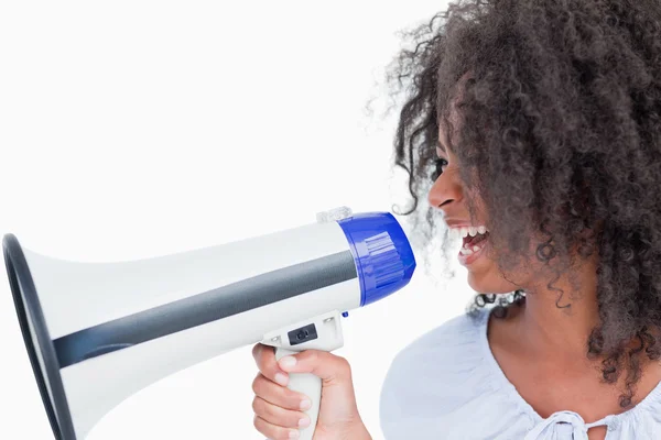 Young woman talking into a megaphone — Stock Photo, Image
