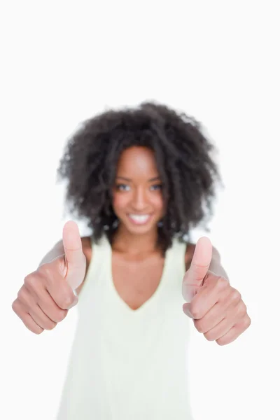 Thumbs up showed by a young woman with curly hair — Stock Photo, Image