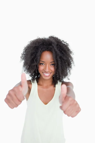 Relaxed young woman putting her thumbs up in satisfaction — Stock Photo, Image