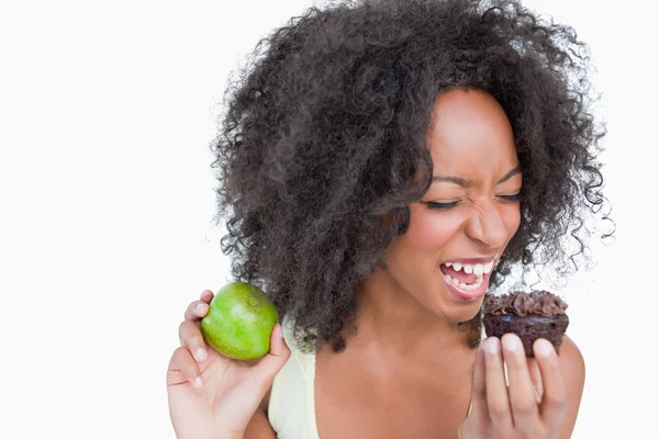 Mujer joven en el punto de comer una magdalena de chocolate —  Fotos de Stock