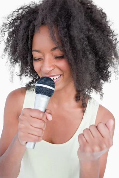 Młoda kobieta śpiewa karaoke z mikrofonem — Zdjęcie stockowe