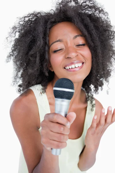 Genç kadının bir mikrofona şarkı konsantre — Stok fotoğraf