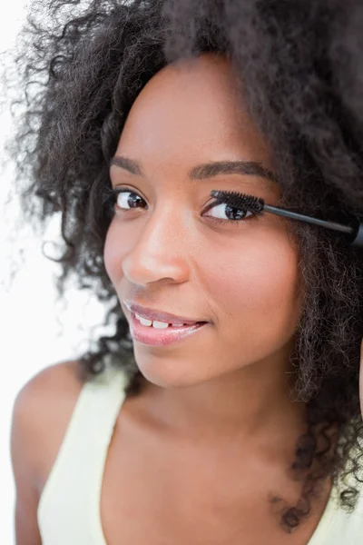 Mosolygó fiatal nő alkalmazása fekete szempillaspirál — Stock Fotó