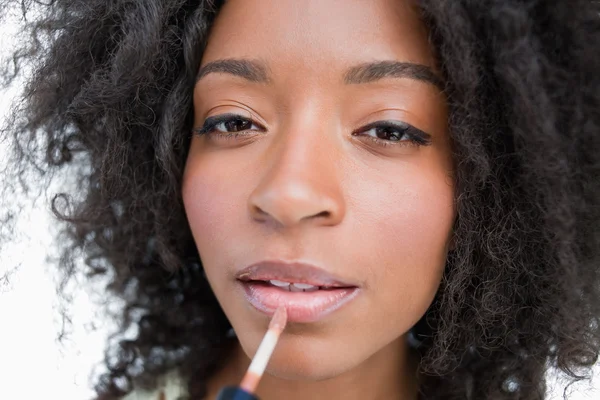 Młoda kobieta za pomocą aplikatora na połysk lip make-up — Zdjęcie stockowe