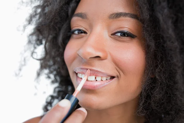Jovem sorrindo mulher make-up ao usar um aplicador de brilho labial — Fotografia de Stock