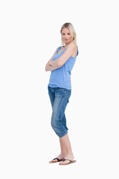 Avslappnad ung kvinna stående upprätt med armarna korsade — Stockfoto