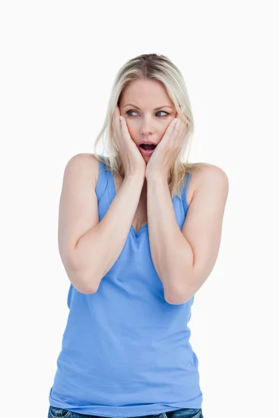Surprised blonde woman placing her hands on her cheeks — Stock Photo, Image