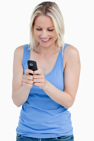 Sorrindo mulher loira enviando uma mensagem com seu celular — Fotografia de Stock