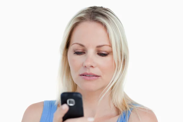 Mulher loira séria segurando seu celular — Fotografia de Stock