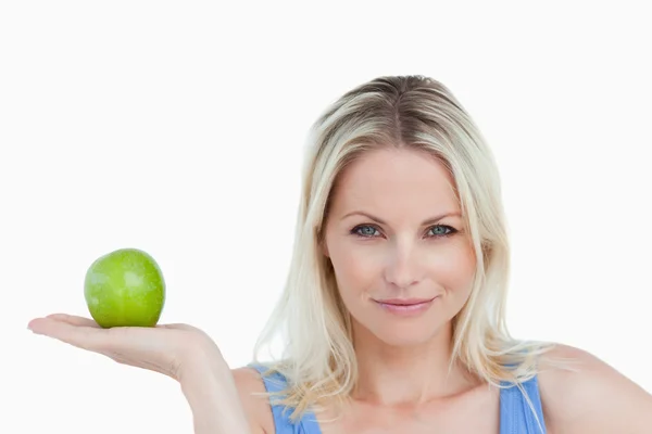 Femme blonde tenant une pomme dans la paume de sa main — Photo