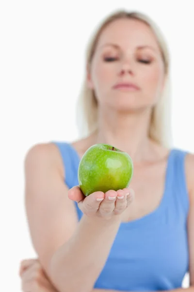 Beautiful green apple held by a blonde woman — Stock Photo, Image