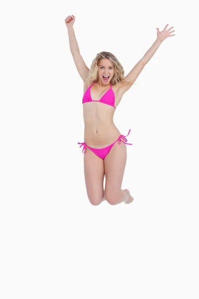 Dynamic blonde woman energetically jumping while wearing swimsui — Stock Photo, Image