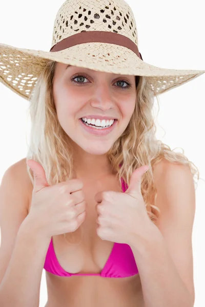 Sonriente joven atractiva mujer poniendo sus dos pulgares hacia arriba — Foto de Stock
