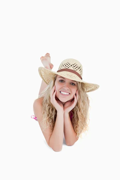 Sonriente adolescente usando un sombrero mientras se acuesta — Foto de Stock