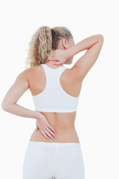 Mulher loira mostrando dor nas costas e no pescoço — Fotografia de Stock