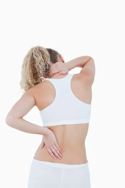 Blonda kvinnan röra henne hals och rygg som ett tecken på smärta — Stockfoto