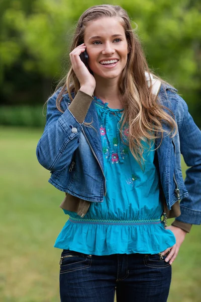 Duran bir PA telefonda konuşurken gülümseyen genç kız — Stok fotoğraf