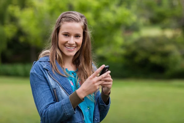 Девочка-подросток отправляет смс со своего мобильного телефона — стоковое фото