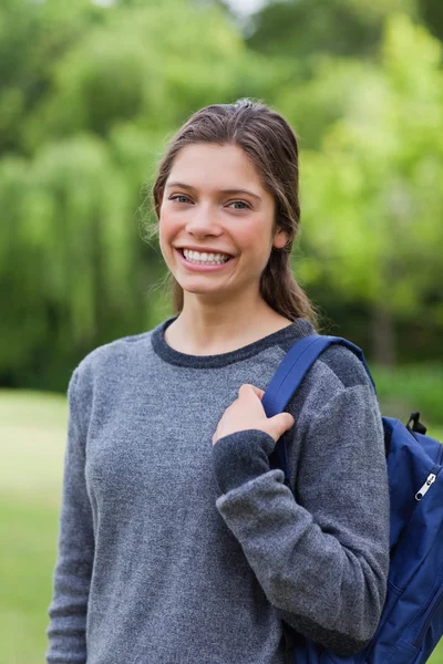 Young girl standing up with hair tied while carrying her backpac — Stock Photo, Image