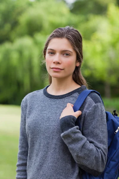 Young relaxed girl looking straight at the camera while standing — Stock Photo, Image