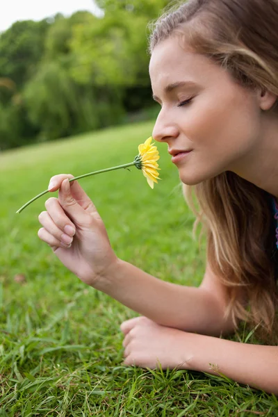 Junge, ruhige Frau schließt die Augen, während sie eine gelbe Blume riecht — Stockfoto