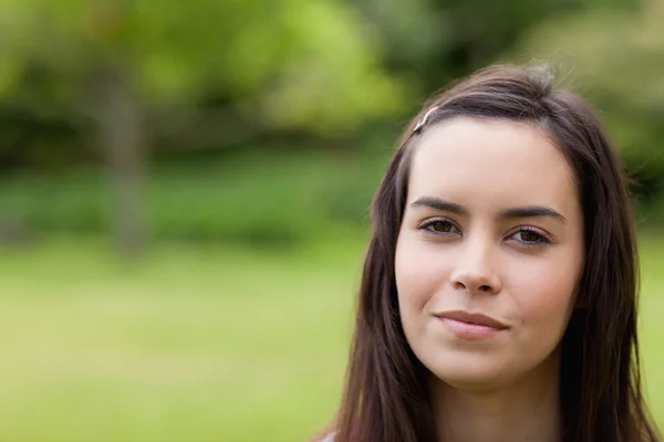 Young calm woman standing upright in a parkland — Stock Photo, Image