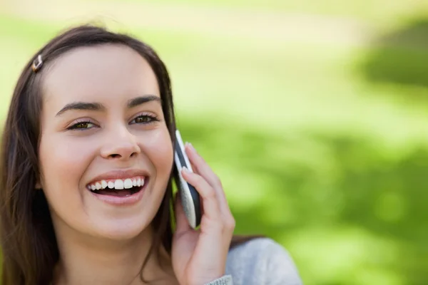 Young laughing woman showing her happiness while talking on the — Stock Photo, Image