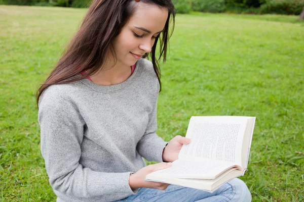 Fiatal lány, egy könyvet olvas ülve egy nyilvános gard nyugodt — Stock Fotó