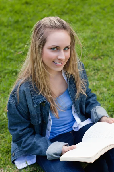 Young smiling woman looking straight at the camera while holding — Stock Photo, Image
