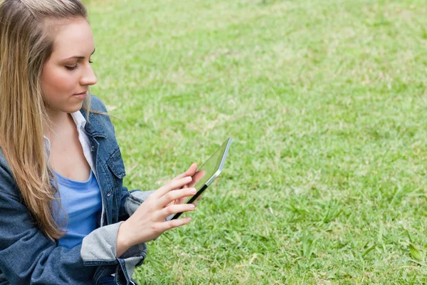 Young serious girl using her tablet pc in the contryside — Stock Photo, Image