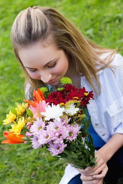 Çekici kız bir demet çiçek kokulu — Stok fotoğraf