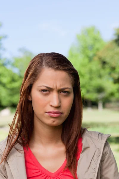 Kvinna som tittar framför henne med en allvarlig uttrycket i hennes ansikte — Stockfoto