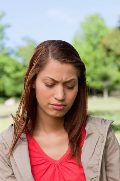 Woman looking downwards with a disappointed expresssion on her f — Stock Photo, Image