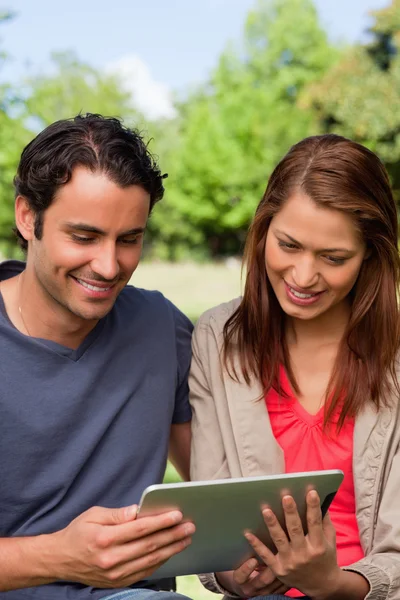 Man en zijn vriend glimlachen als het horloge iets op een Tablet PC — Stockfoto