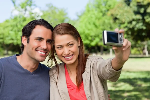 stock image Woman takes a picture of her friend and herself with a camera