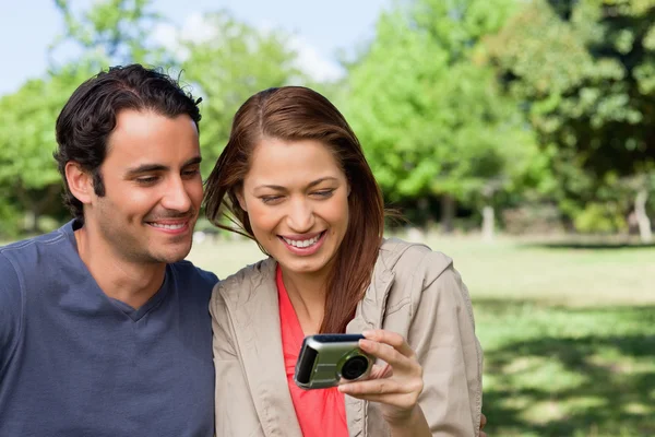 Woman and her friend looking at pictures on a camera — Stock Photo, Image